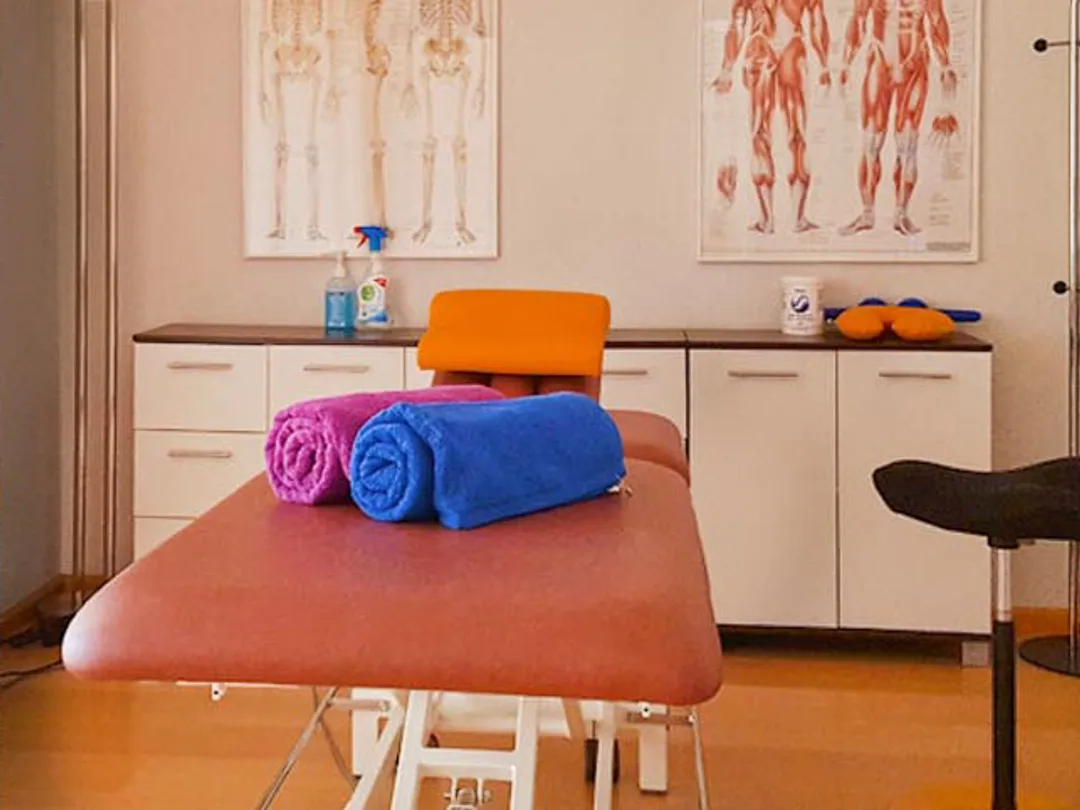 Behandlungsraum mit anatomischen Lehrtafeln